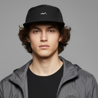 Person wearing a gray jacket, black cap, and black shirt on a gray background